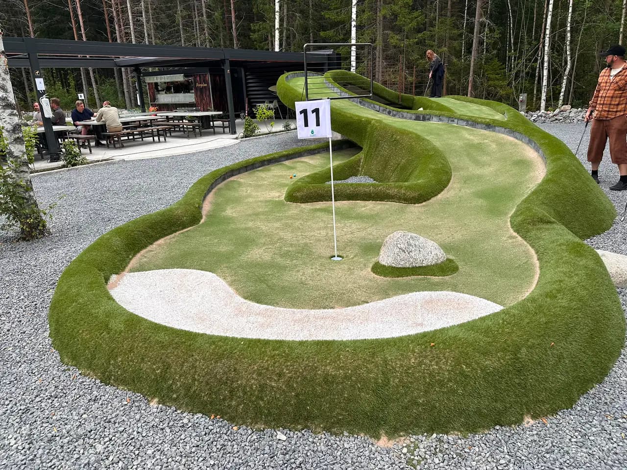 Äventyrsgolfbana i naturmaterial med konstgräs, sandbunker och natursten på Hudiksvalls Äventyrsgolf